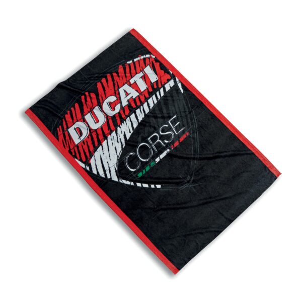 The Ducati Corse Sketch beach towel is the perfect accessory for summer. It is soft thanks to the tip-sheared terry cotton velour with a shiny external effect and has excellent internal drying qualities. Outstanding are the particular graphic design of the shield on a black background with red edging.